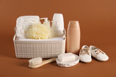 Photo of Baby accessories and body care products on brown background