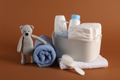 Photo of Baby accessories and body care products on brown background