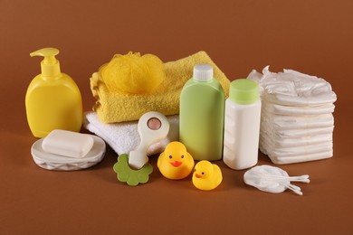 Photo of Baby accessories and body care products on brown background