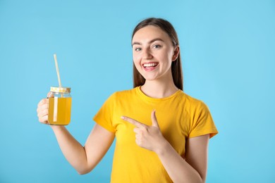 Photo of Woman with refreshing drink and straw on light blue background