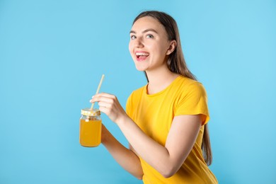 Photo of Woman with refreshing drink and straw on light blue background