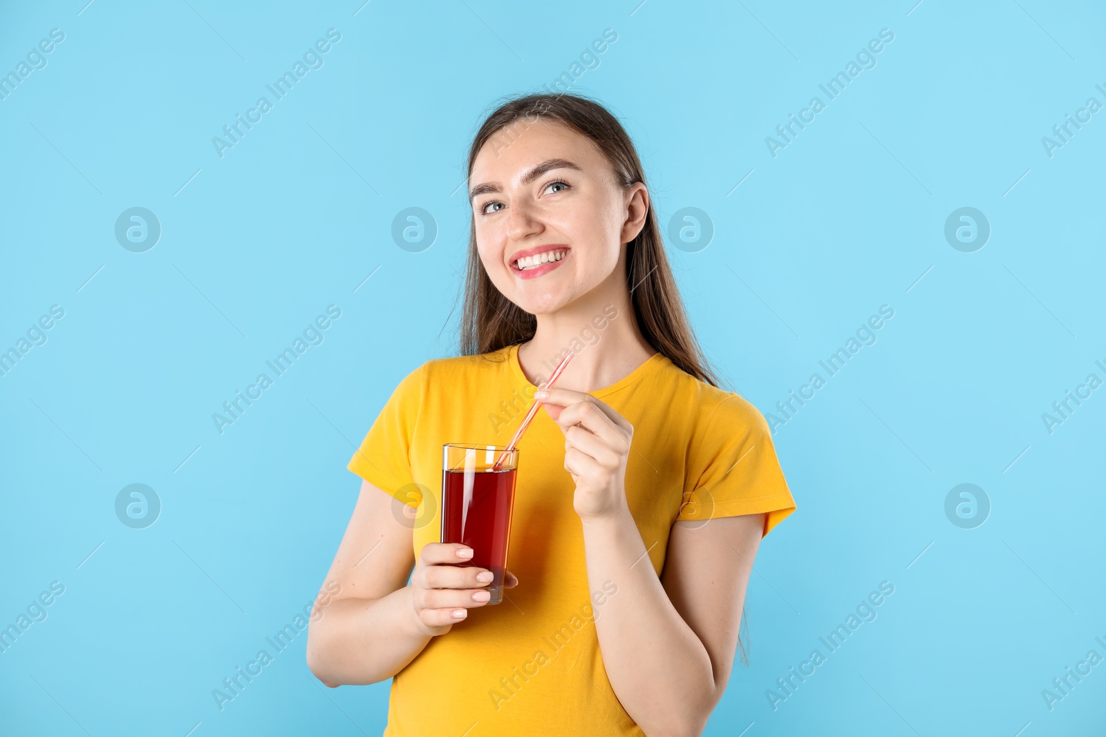 Photo of Woman with refreshing drink and straw on light blue background