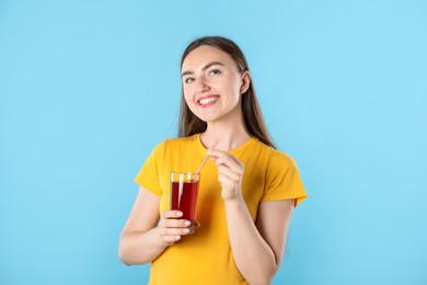 Photo of Woman with refreshing drink and straw on light blue background
