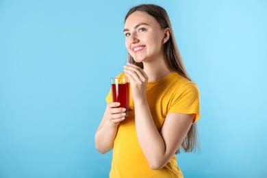 Photo of Woman with refreshing drink and straw on light blue background