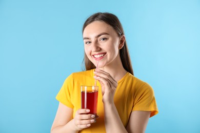 Photo of Woman with refreshing drink and straw on light blue background