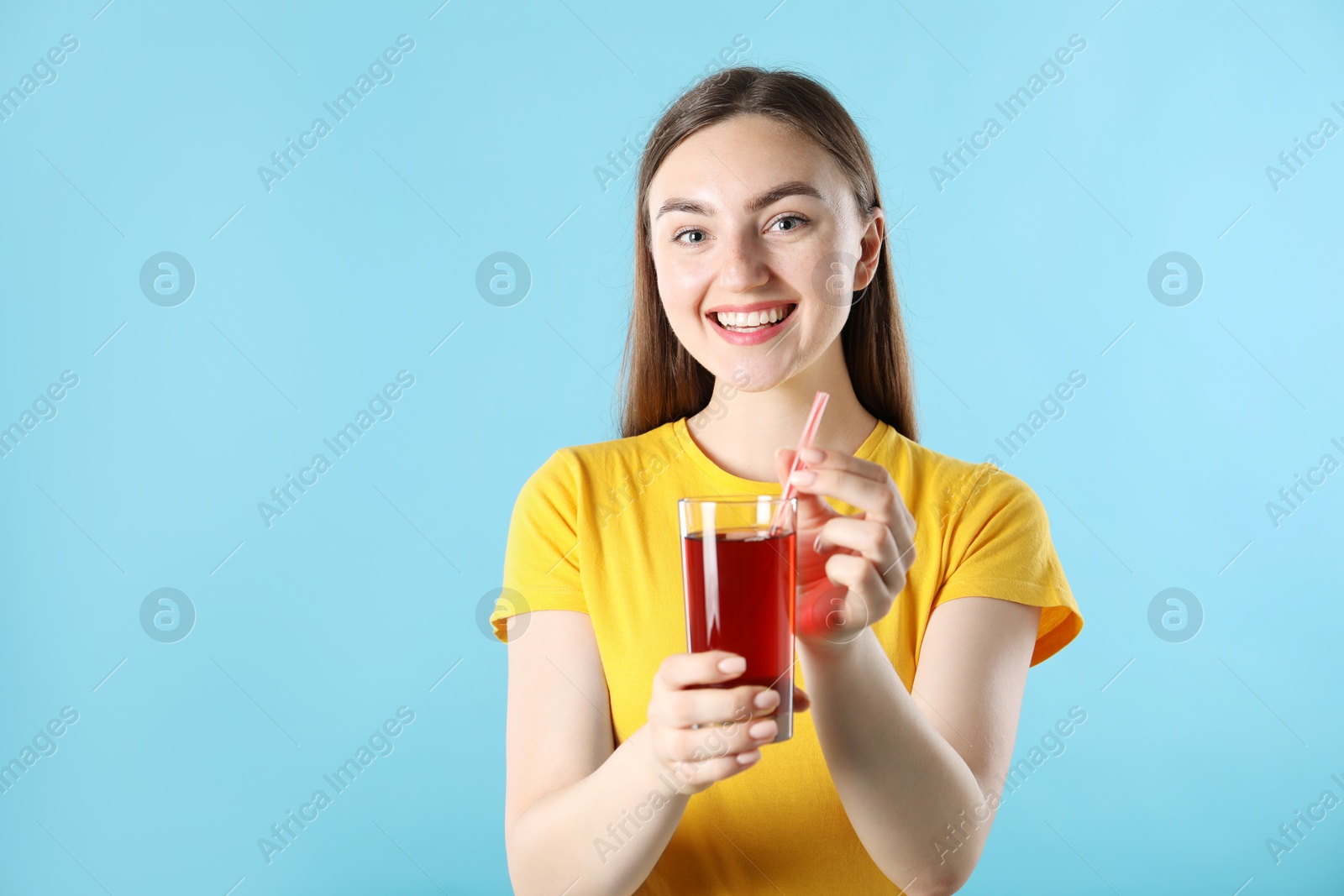 Photo of Woman with refreshing drink and straw on light blue background, space for text