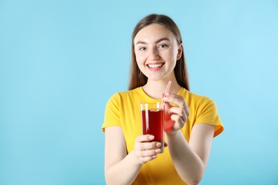 Photo of Woman with refreshing drink and straw on light blue background, space for text