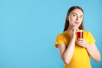 Photo of Woman with refreshing drink and straw on light blue background, space for text