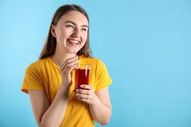 Photo of Woman with refreshing drink and straw on light blue background, space for text
