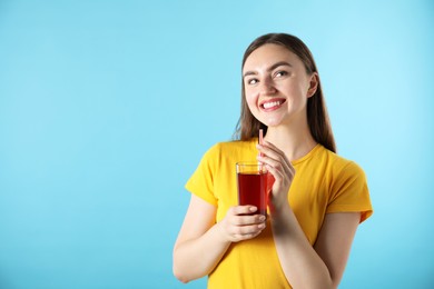 Photo of Woman with refreshing drink and straw on light blue background, space for text