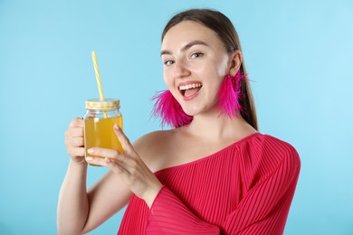Photo of Woman with refreshing drink and straw on light blue background
