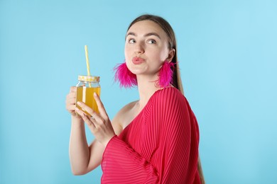 Photo of Woman with refreshing drink and straw on light blue background