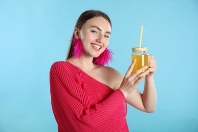 Photo of Woman with refreshing drink and straw on light blue background