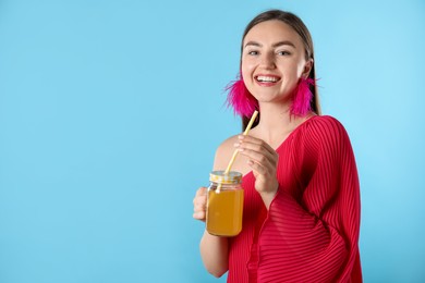 Photo of Woman with refreshing drink and straw on light blue background, space for text