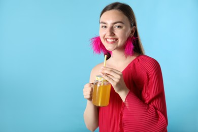 Photo of Woman with refreshing drink and straw on light blue background, space for text