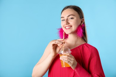 Photo of Woman with refreshing drink and straw on light blue background, space for text