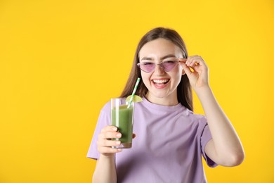 Photo of Woman with refreshing drink and straw on orange background, space for text