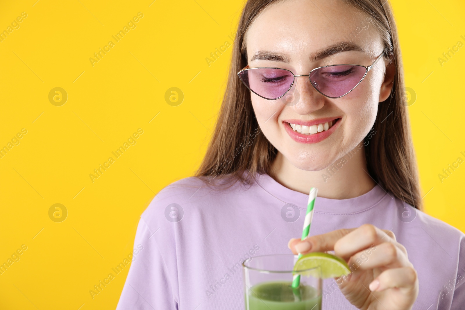 Woman with refreshing drink and straw on orange background, space for text Photo of Woman with refreshing drink and straw on orange background, space for text