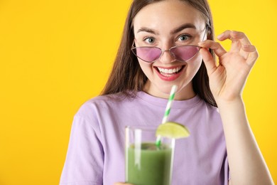 Photo of Woman with refreshing drink and straw on orange background