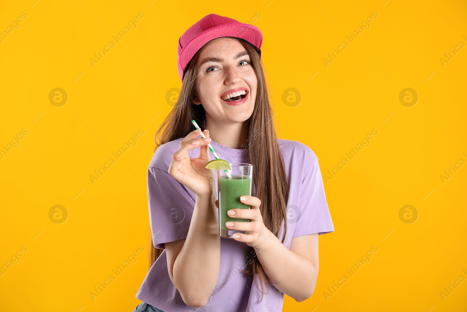 Woman with refreshing drink and straw on orange background Photo of Woman with refreshing drink and straw on orange background