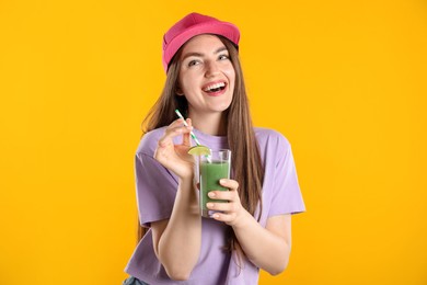 Photo of Woman with refreshing drink and straw on orange background
