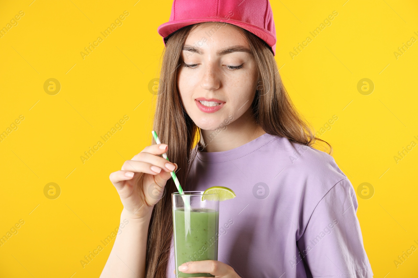 Woman with refreshing drink and straw on orange background Photo of Woman with refreshing drink and straw on orange background