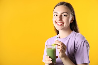 Photo of Woman with refreshing drink and straw on orange background, space for text
