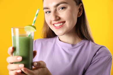 Photo of Woman with refreshing drink and straw on orange background
