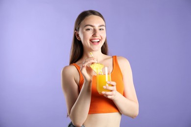 Photo of Woman with refreshing drink and straw on violet background