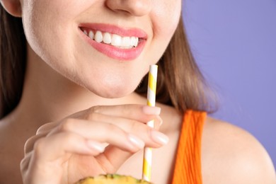Photo of Woman with drinking straw on violet background, closeup
