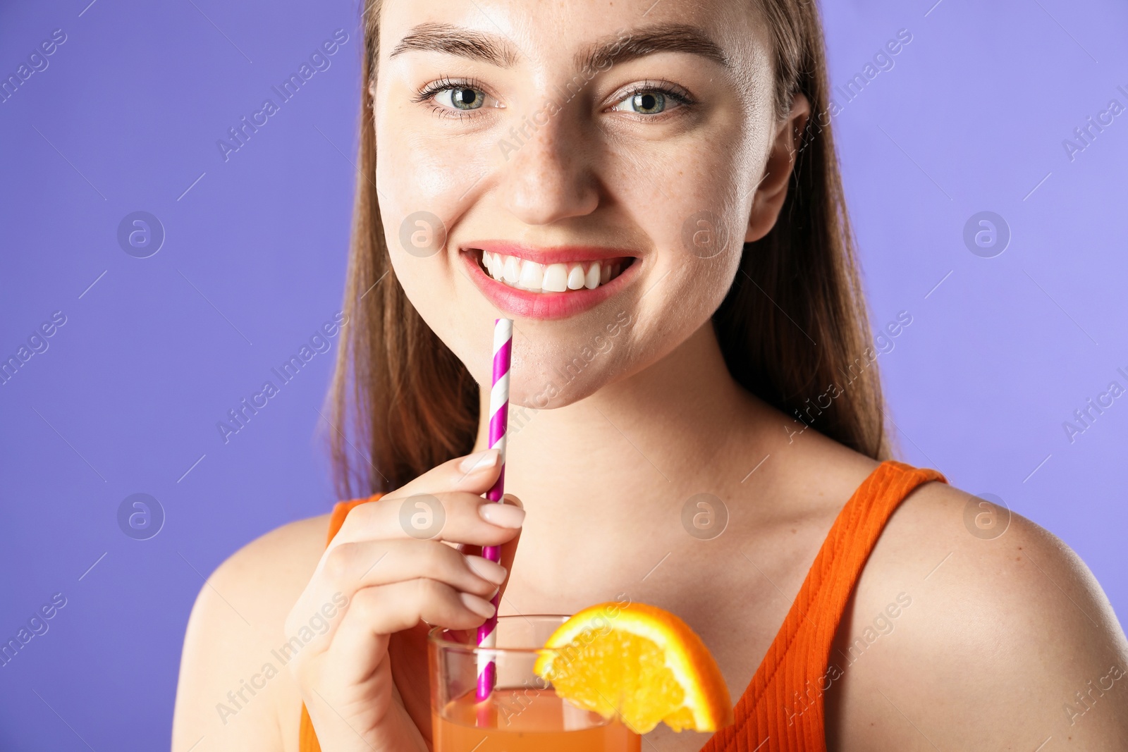 Photo of Woman with refreshing drink and straw on violet background