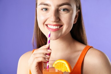 Photo of Woman with refreshing drink and straw on violet background