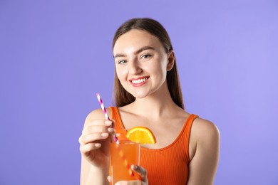 Photo of Woman with refreshing drink and straw on violet background