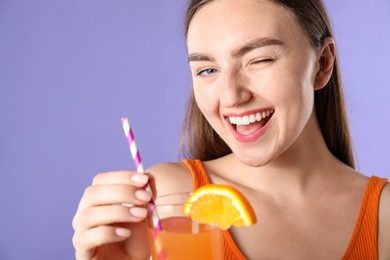 Photo of Woman with refreshing drink and straw on violet background