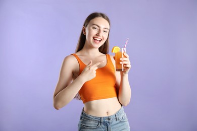 Photo of Woman with refreshing drink and straw on violet background