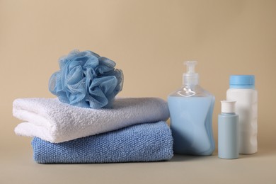 Photo of Baby accessories and body care products on beige background