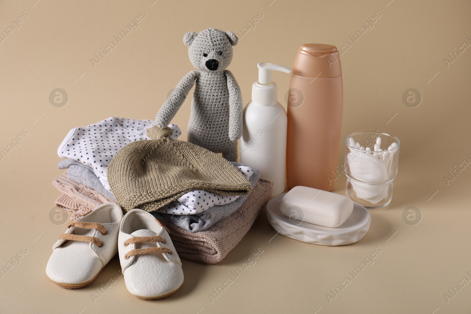 Photo of Baby accessories, clothes and body care products on beige background