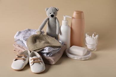 Photo of Baby accessories, clothes and body care products on beige background