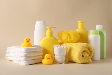 Photo of Baby accessories and body care products on beige background