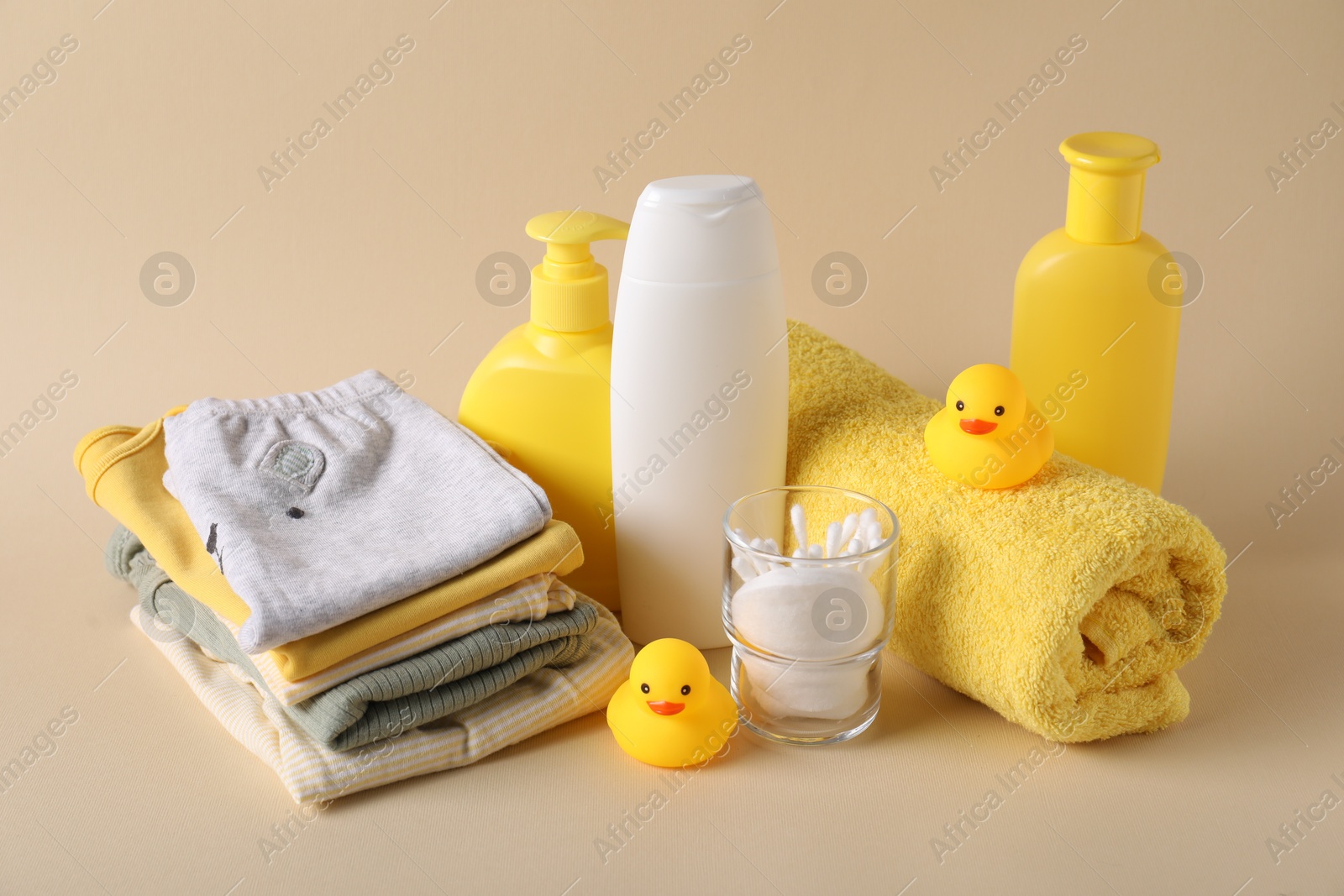 Photo of Baby accessories, clothes and body care products on beige background