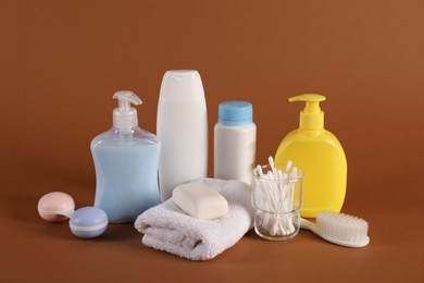 Photo of Baby accessories and body care products on brown background