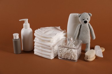 Photo of Baby accessories and body care products on brown background