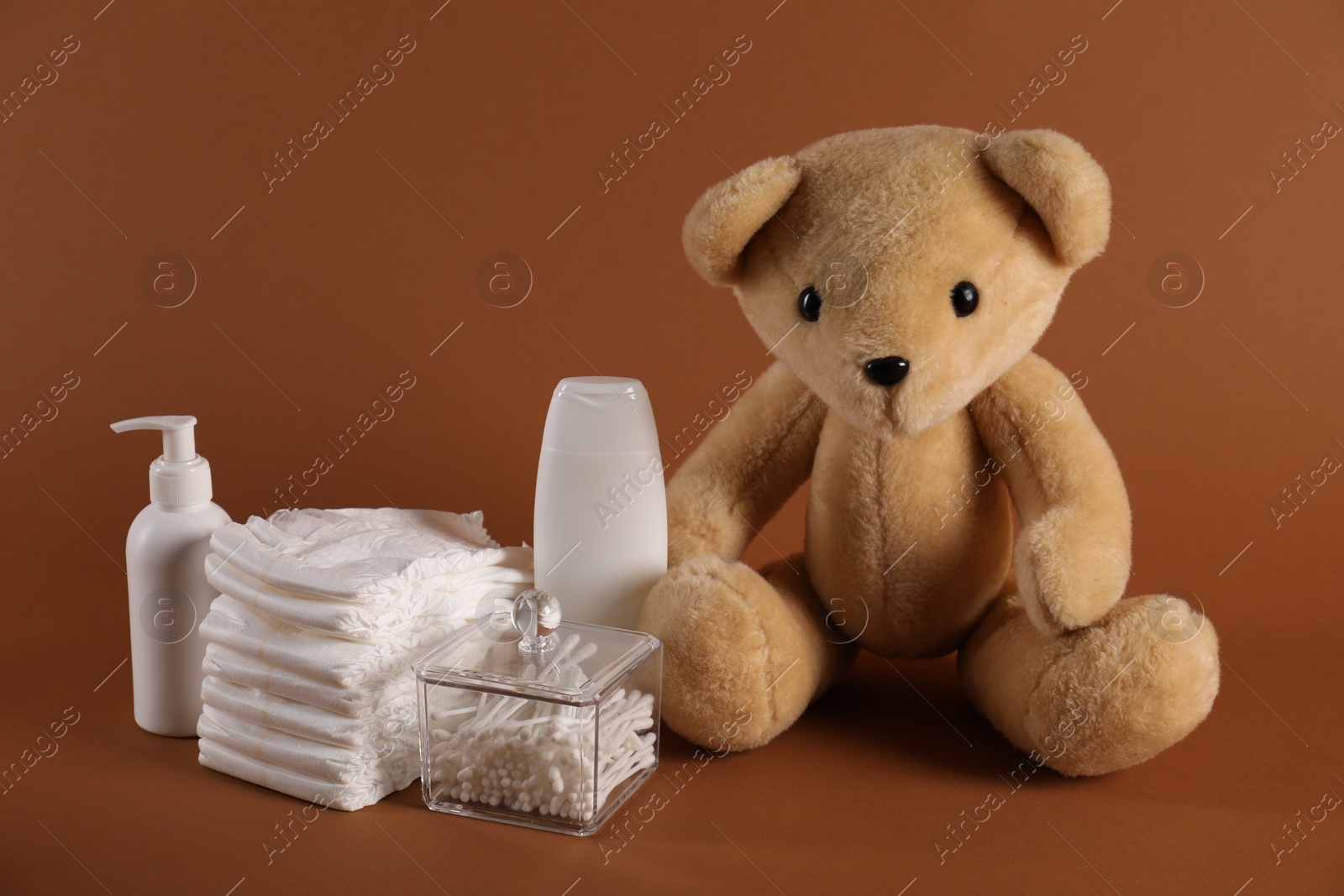 Photo of Baby accessories and body care products on brown background
