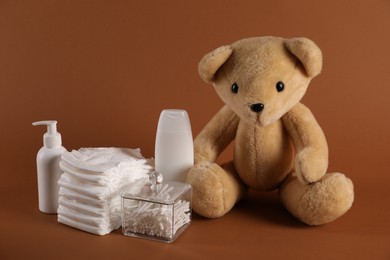 Photo of Baby accessories and body care products on brown background