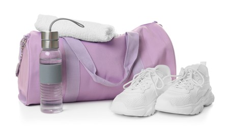 Photo of Stylish gym bag with towel, bottle and sneakers isolated on white