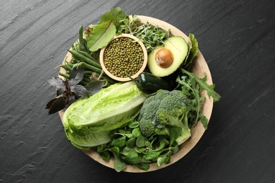 Photo of Superfood. Healthy food products in bowl on black table, top view