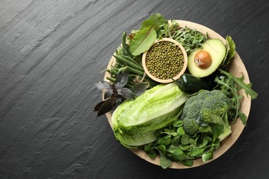 Photo of Superfood. Healthy food products in bowl on black table, top view. Space for text