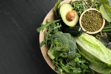 Photo of Superfood. Healthy food products in bowl on black table, top view. Space for text