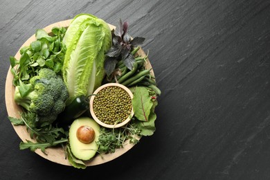 Photo of Superfood. Healthy food products in bowl on black table, top view. Space for text