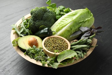 Photo of Superfood. Healthy food products in bowl on black table, closeup